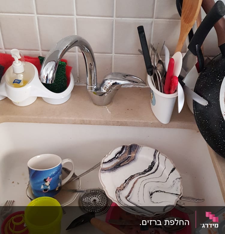 כיור עם כלים מלוכלכים וברז מטבח